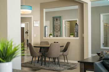 A dining room with a table and chairs.